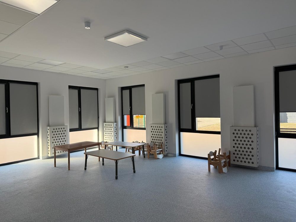 Sala ze stolikami, rolety w kasecie z prowadnicami w każdym oknie